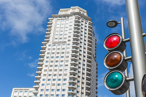 Madrid, Spain. March 7 2022. Spain square traffic light in Madrid. In the background Edificio Madrid tower. Sunny day