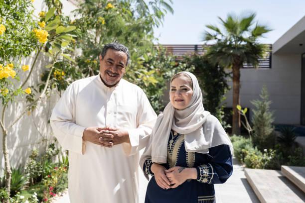 Portrait of mature Saudi couple standing outside family home stock photo