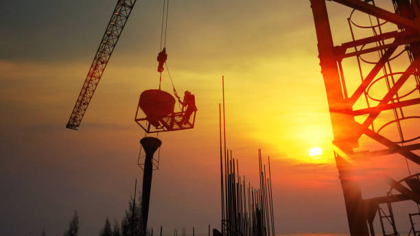 istock construction worker workloads in construction site . the worker put on cement reinforced in to the form with abstract sky sunset nature background 1392081119