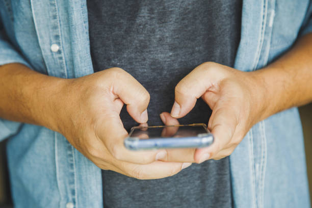 istock Close up a man holding texting message chatting with friend with mobile phone 1392081306