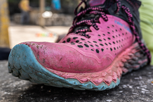 Worn and dirty running shoe, with attractive pink and blue colors.