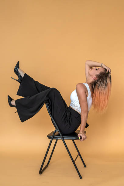 istock beautiful pretty young girl posing for a portrait on a solid peach background. 1392088647