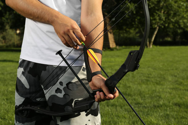 istock Man with bow and arrow practicing archery in park, closeup 1392090554