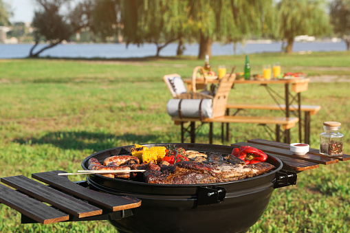 Tasty meat and vegetables on barbecue grill outdoors. Space for text