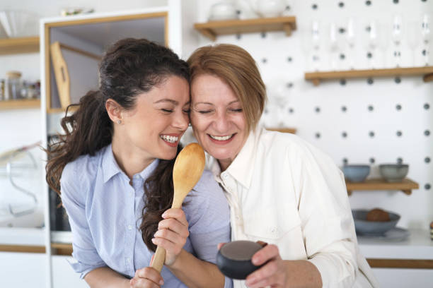 istock Mother and daughter having fun together while dancing in the kitchen 1392090865