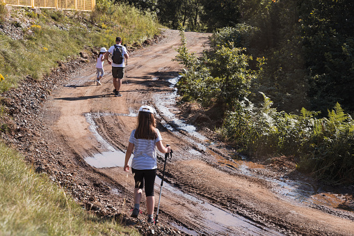 Family leaving hiking trail made of mud and puddles