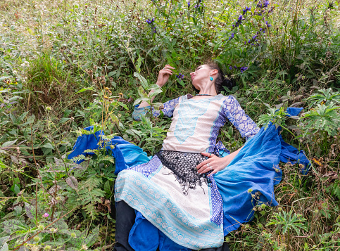 a woman is resting on a flower meadow, the Carpathian mountains, summer