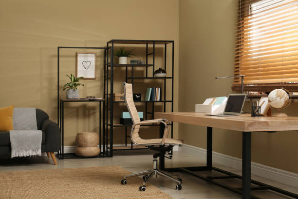 istock Comfortable workplace with laptop on wooden table in room. Interior design 1392093573