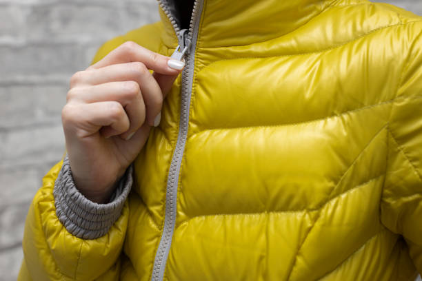 istock a woman zips up her jacket around her throat 1392096121