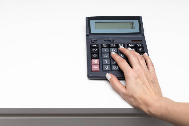 istock woman's hand presses the calculator button with a finger 1392096201