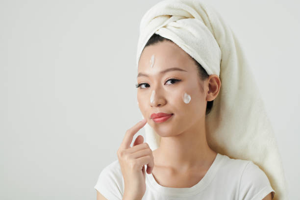 istock Young Woman Applying Face Cream 1392097811