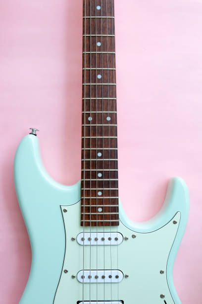 Detail of Mint Green Electric Guitar on a Pink background.
