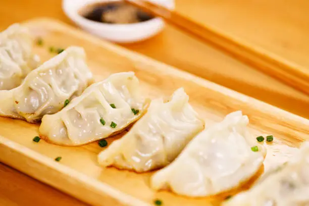 Photo of Fried gyoza dumplings with wooden chopstick