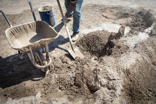 istock Worker prepare concrete with shovel at construction site. 1392099108