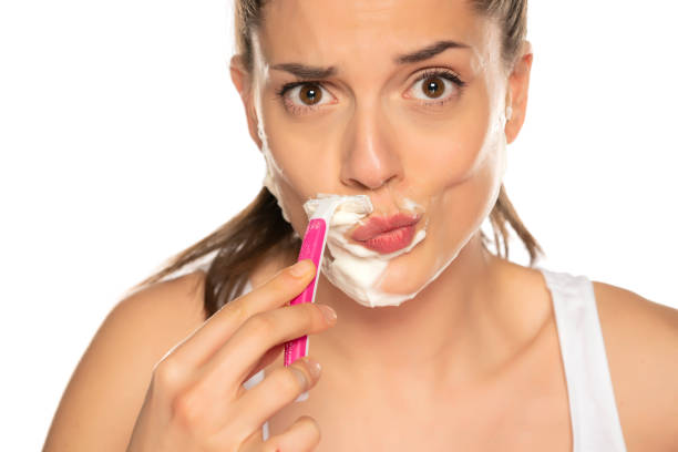 istock Young funny woman shaves her face 1392099160