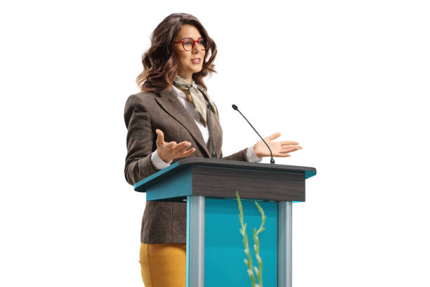 istock Young woman speaker on a pedestal gesturing with hands 1392101095