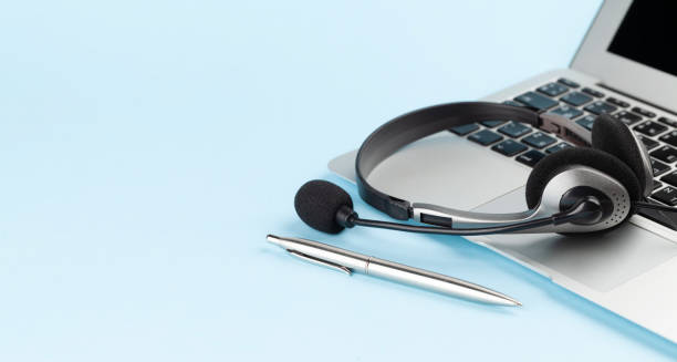 istock Headset over laptop on blue background 1392103917