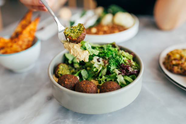 Woman Eating Falafel in a Restaurant Arabian style appetizer. Healthy vegan and vegetarian food concept. vegan food stock pictures, royalty-free photos & images