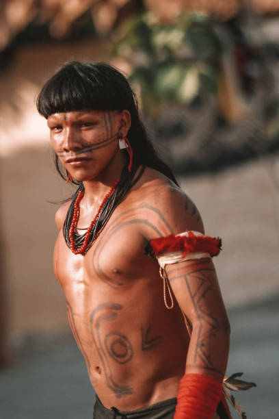 indigenous young man of muscular built wearing body paint - tribal art fotos imagens e fotografias de stock