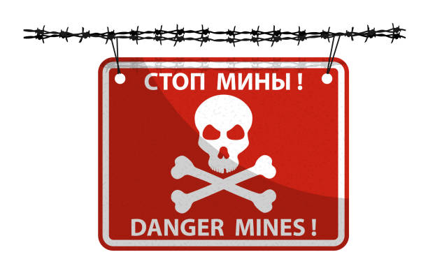 istock red sign plate with skull and crossbones hangs on barbed wire. Hazard symbol, minefield designation with inscription in Russian and English STOP MINES. Vector isolated on white 1392110672