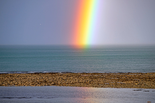 rainbow in atlantic ocean coast in the sunset