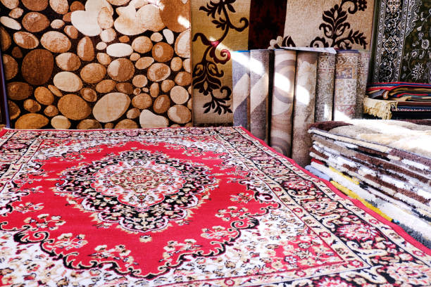 Stack of multicolored quality rugs at carpet shop, Carpets variety selection rolled up rugs shop store.