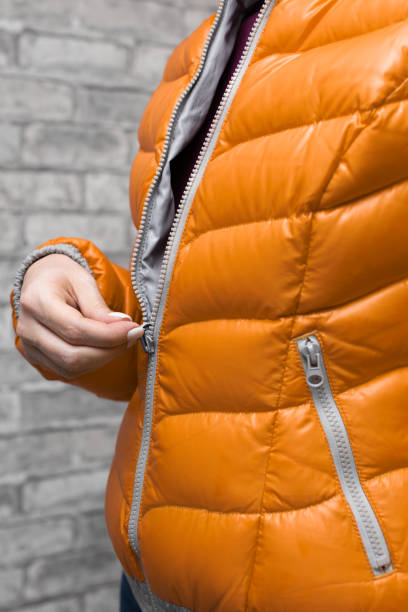 istock woman zips up her warm colored jacket 1392112686