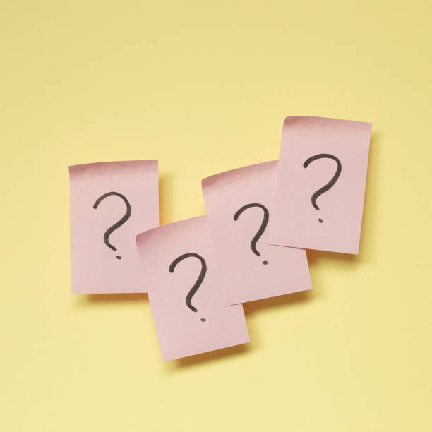 istock Question mark on pink memo paper on yellow background 1392114569