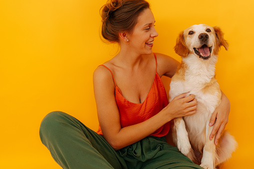 Portrait of a dog and young woman, his owner - studio shot, isolated