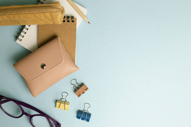 istock Notepad, clip, pencil, pouch, pencil case, glasses on blue background. flat lay, top view, copy space 1392114762