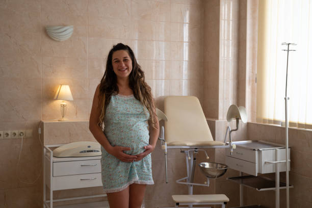 the pregnant woman stands in the ward of the maternity hospital. - one woman only young women people nightie imagens e fotografias de stock