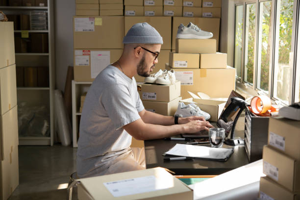istock E-commerce male business owner working on laptop computer in store warehouse. 1392117080