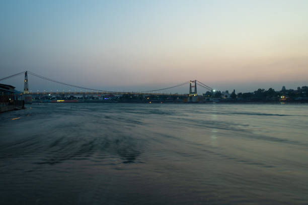 puente colgante de hierro con cielo dramático al atardecer y agua borrosa del río por la mañana - photography suspension bridge water night fotografías e imágenes de stock