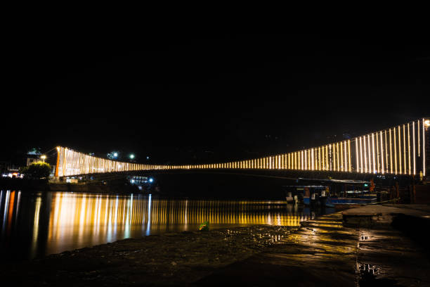 puente colgante de hierro iluminado con luces de ferry con reflexión del agua desde diferentes ángulos - photography suspension bridge water night fotografías e imágenes de stock