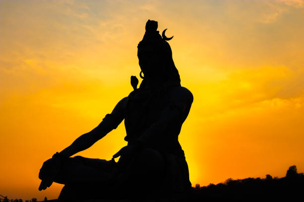 back lit statue of hindu god lord shiva in meditation posture with dramatic sky from unique angle back lit statue of hindu god lord shiva in meditation posture with dramatic sky from unique angle image is taken at parmarth niketan rishikesh uttrakhand india. lord shiva stock pictures, royalty-free photos & images
