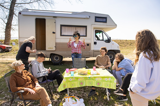 Caucasian family enjoy the picnic/camping while traveling with camper van