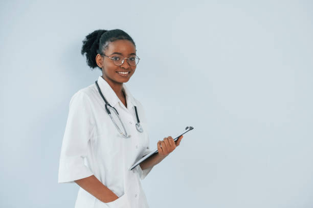 istock Young african american doctor is against white background 1392119953