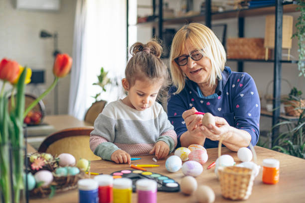 easter egg painting with grandmother - child easter egg home improvement easter imagens e fotografias de stock