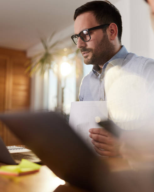 istock Young businessman working on laptop at home office. 1392121041