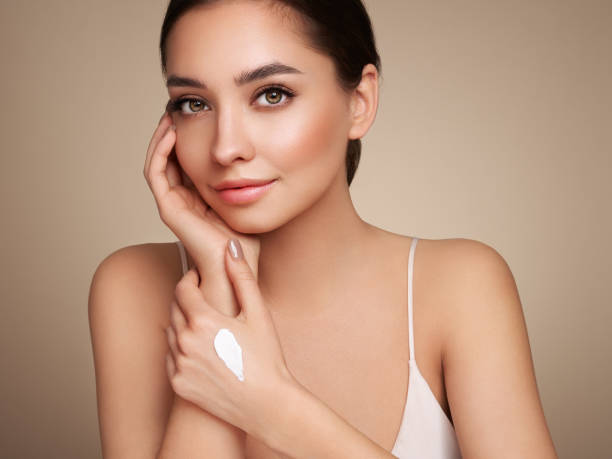 istock Beauty woman applying cream on her hands 1392122390