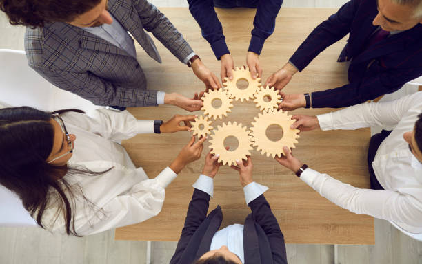 istock People stacking wooden gears next to each other, symbolizing development and success. 1392123676