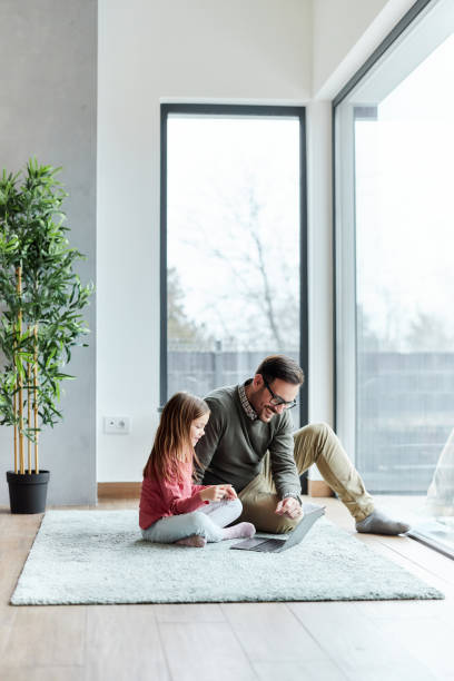 istock Happy single father and his daughter using computer at home. 1392123916