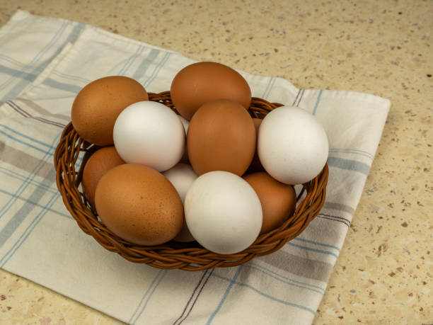istock Fresh eggs in wicker basket on wood table. Close-up. Copy space. 1392123996