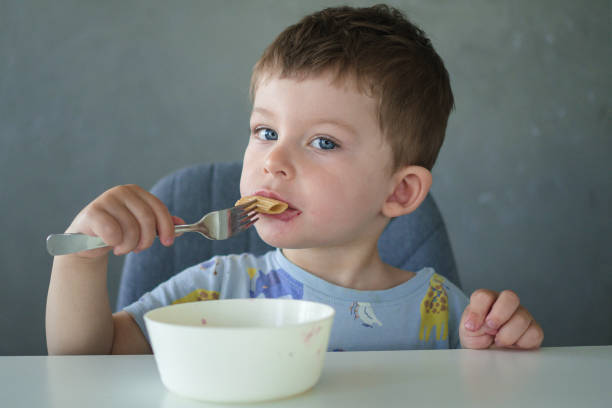 istock Little boy eating pasta 1392125177