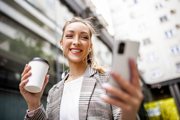 istock Self-confident young woman using phone wearing headphones 1392125315