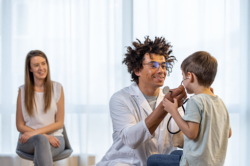 A super adorable boy is at his doctor's office for a check up.