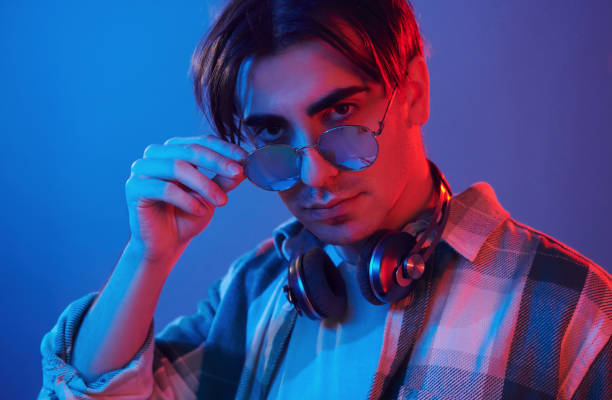 istock Conception of futuristics. Man standing in the studio with neon light 1392128629