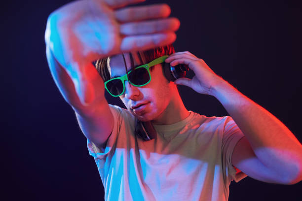 istock Dj is having fun. Man standing in the studio with neon light 1392128721