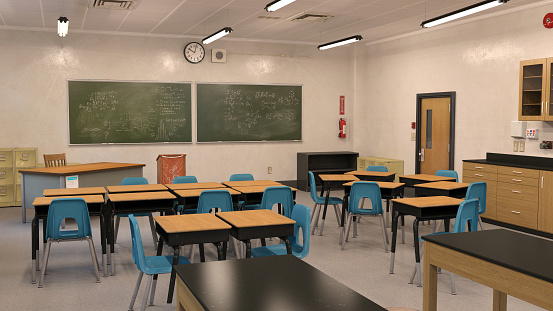 In Elementary School Classroom Brilliant Black Girl Writes in Exercise Notebook, Taking Test and Writing Exam. Junior Classroom with Diverse Group of Children Working Diligently and Learning New Stuff