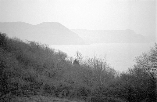 Looking across the sea from Lyme Regis towards Golden Cap on the Jurassic Dorset coast, 35mm film